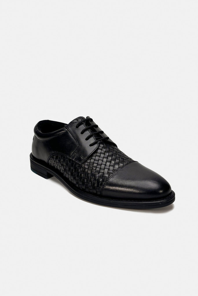 Black leather dress shoe with woven pattern on a white background